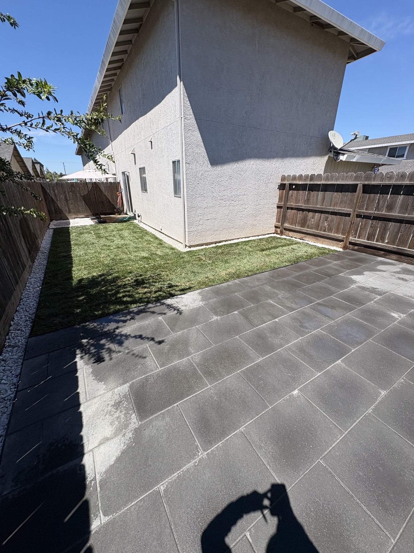Residential property improvement with new lawn, pavers, and clean border stone